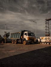 a dump truck parked in a parking lot under a cloudy sky