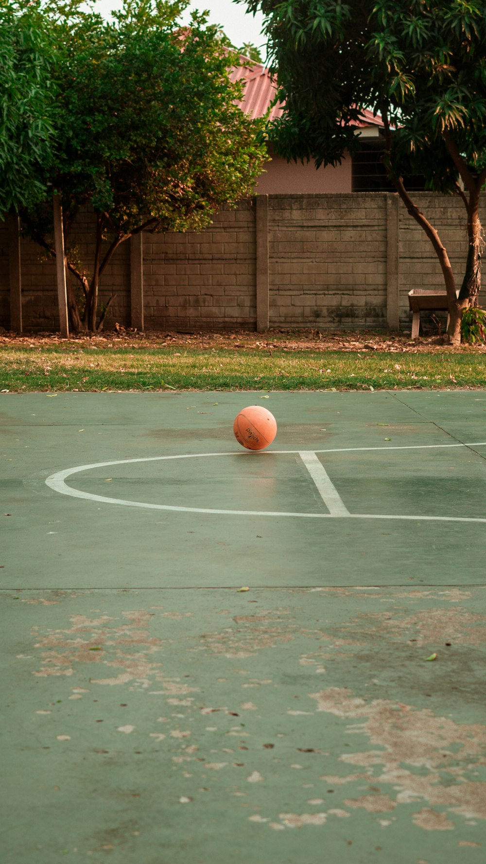 Ein orangefarbener Ball, der auf einem Basketballfeld sitzt