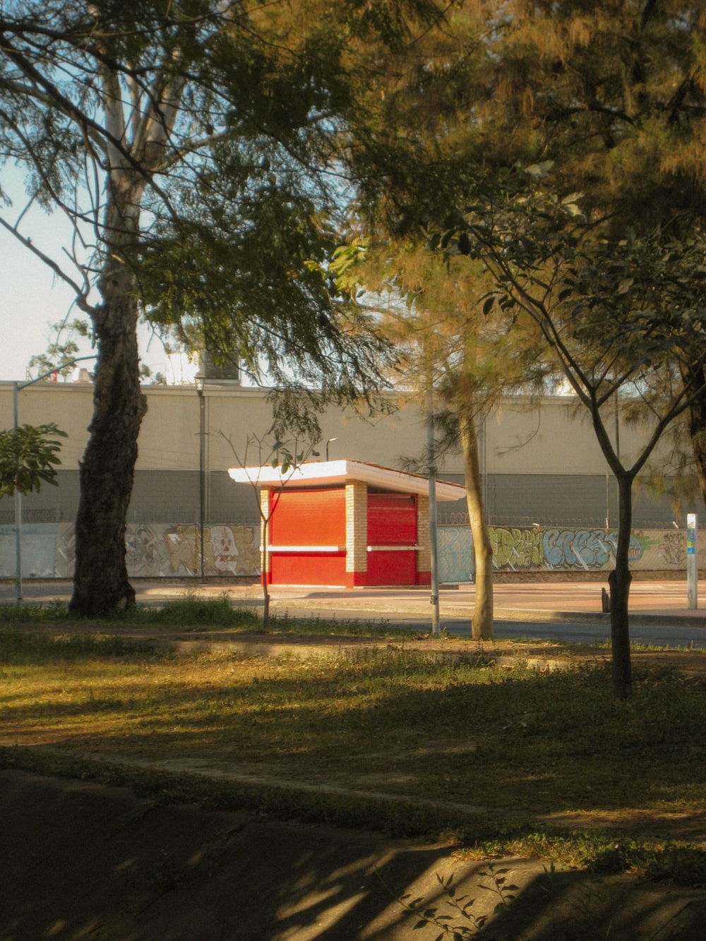 a red building sitting next to a lush green park