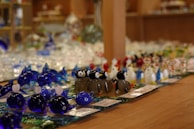 A collection of small glass figurines displayed on a shelf, each with unique colors and shapes.