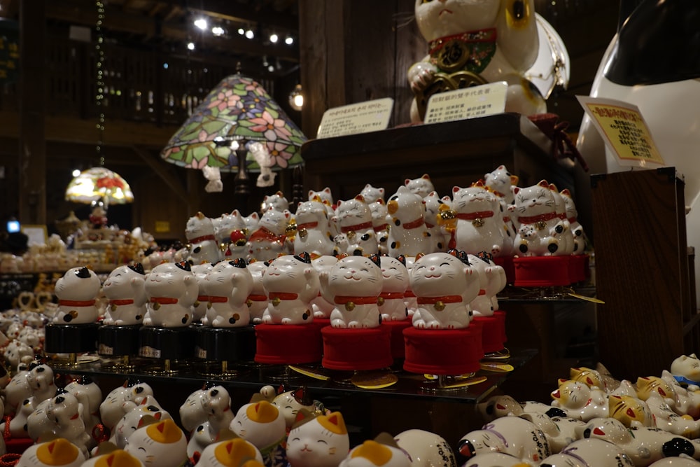 a display case filled with lots of white and red cat figurines