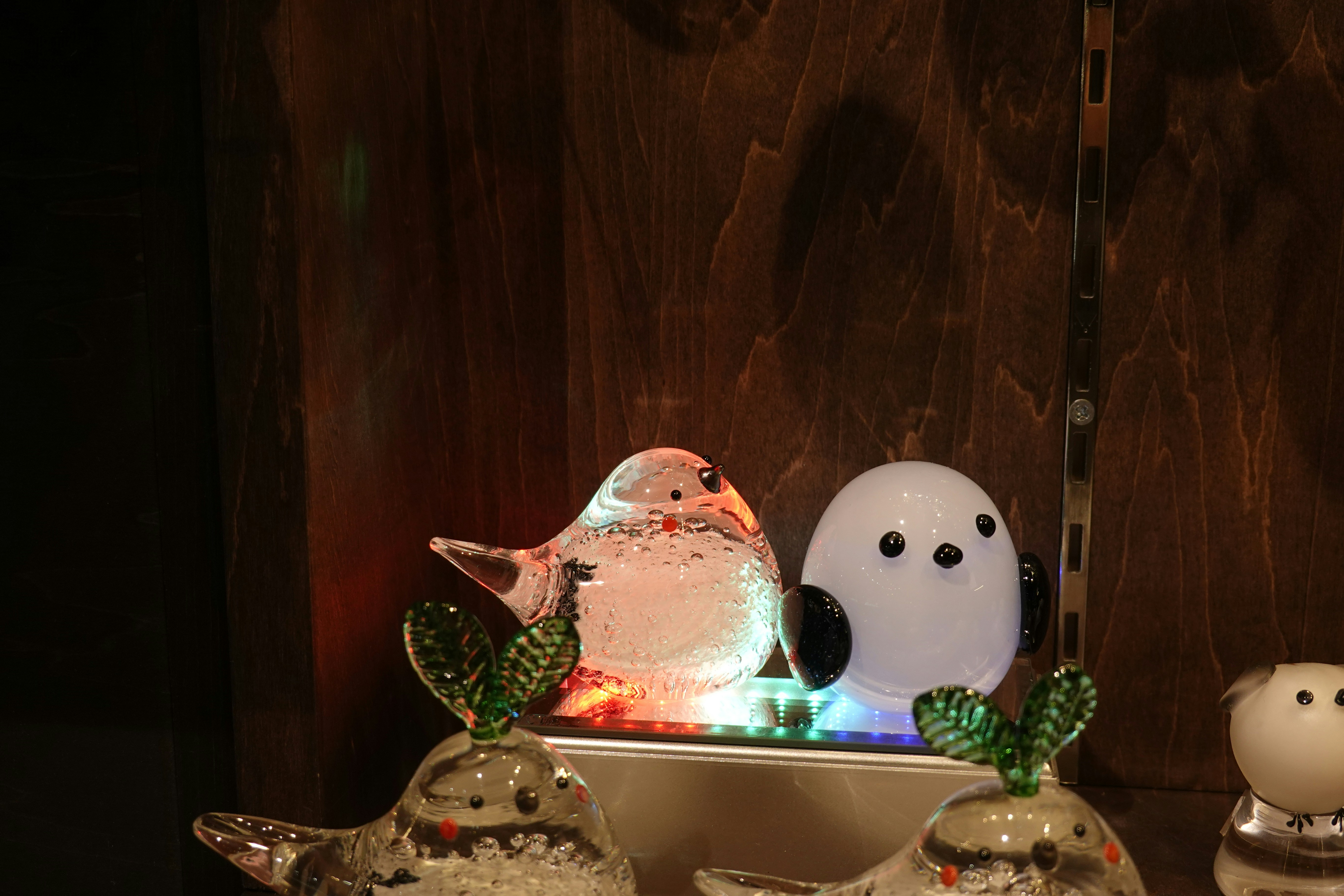 um par de pássaros de vidro sentados em cima de um balcão