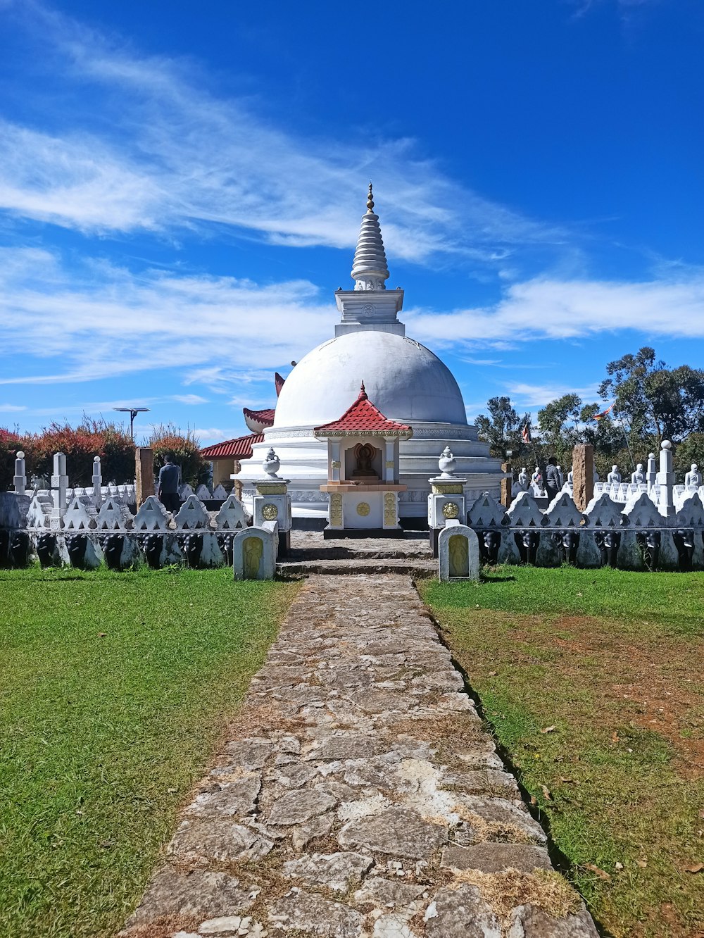 a large white building sitting on top of a lush green field