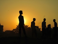 Sunset over the Malagasy landscape with silhouettes of people walking home after a day of work.