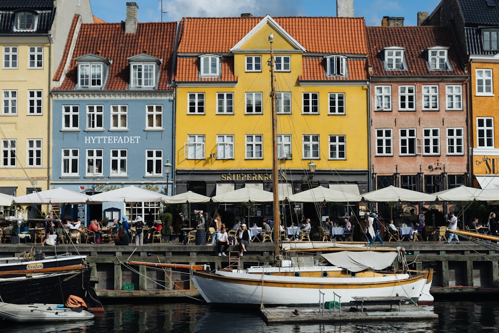 a group of boats docked in front of a row of colorful buildings