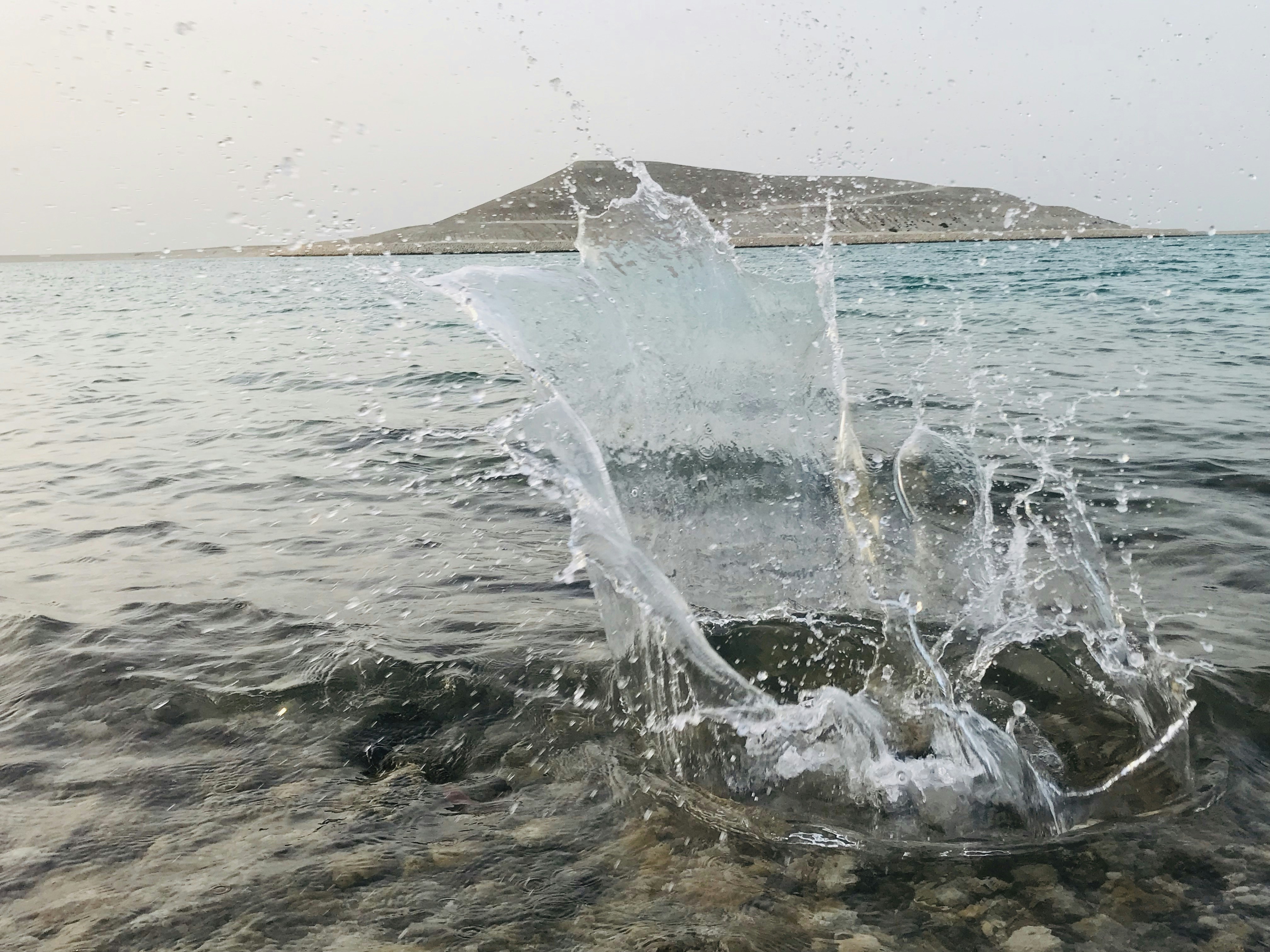 uno spruzzo d'acqua su una roccia in uno specchio d'acqua