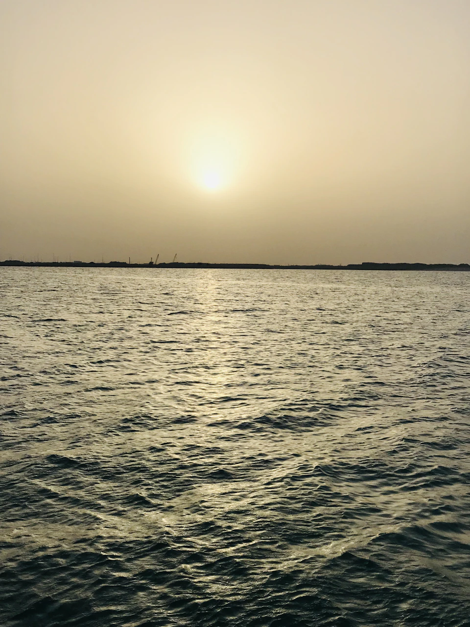 Serene sunset over water with warm glow across the sky and reflected light