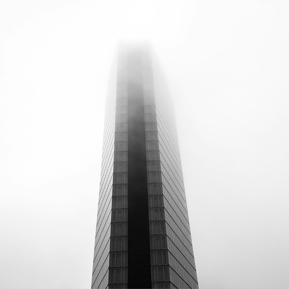 a very tall building in the middle of a foggy day