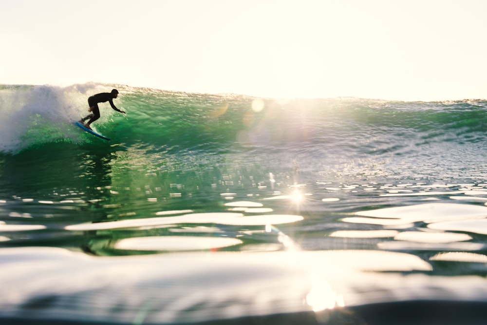 a man riding a wave on top of a surfboard