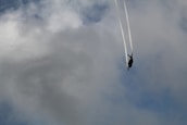 Modern fighter jet soaring above clouds during a training exercise.