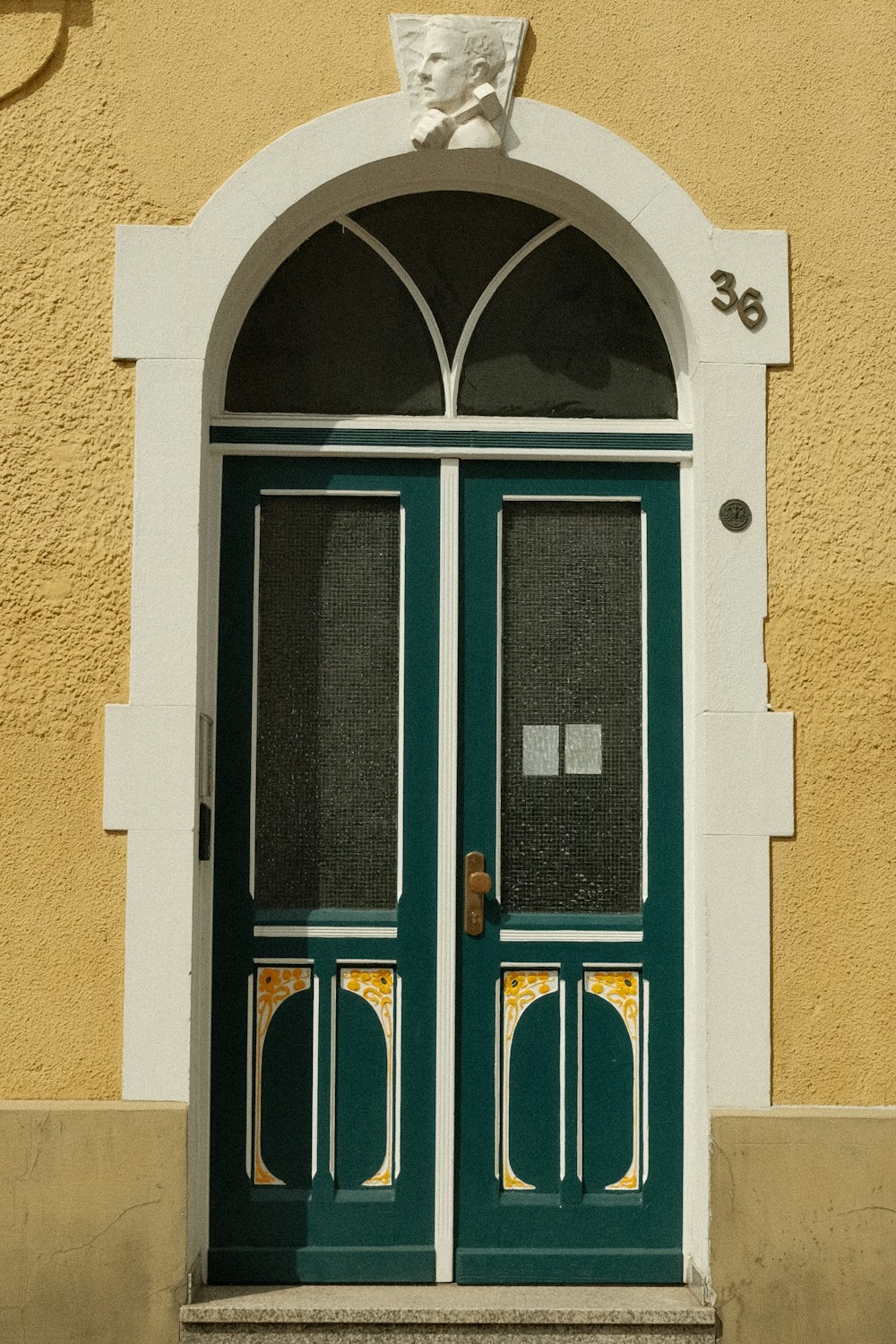 a green and white door and window on a building