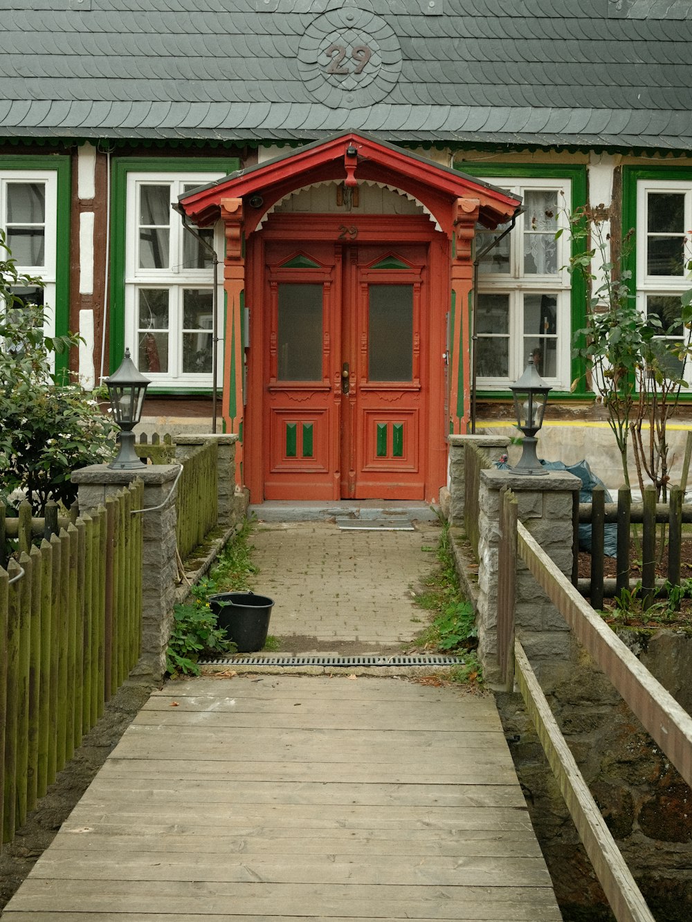 a wooden walkway leading to a red door
