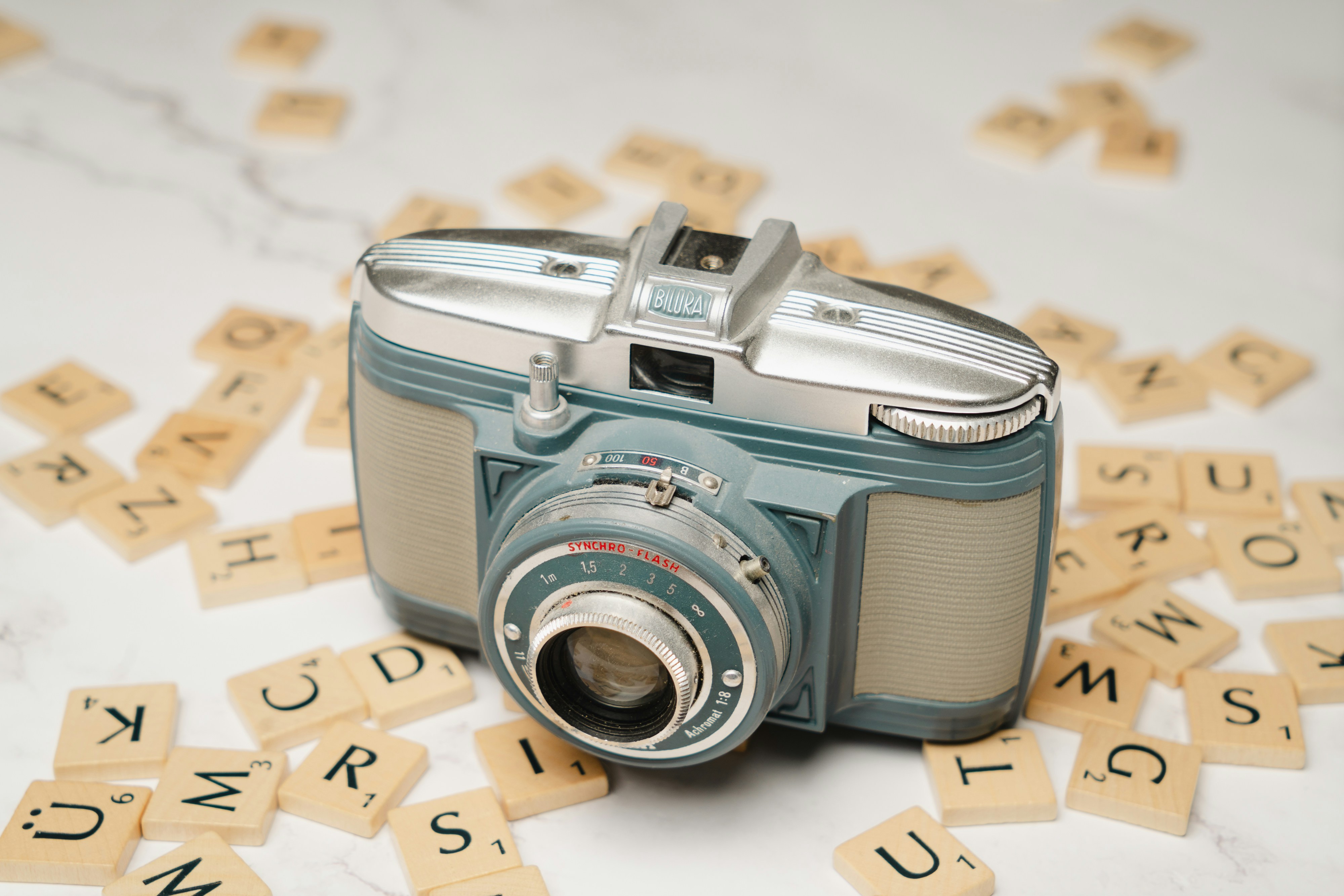 A camera sitting on top of scrabble letters photo – Free Photography ...