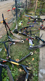 Outdoor toys including bikes and scooters arranged on a grassy lawn.