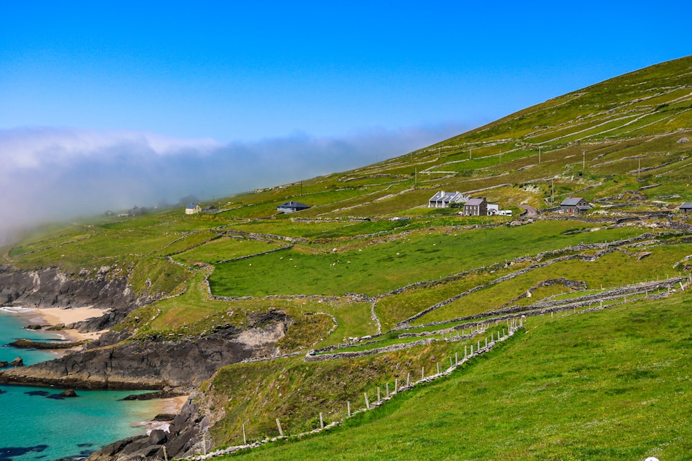 a grassy hill with a body of water next to it