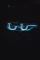 Close-up of a sleek Plaser LED bulb glowing with green and white light inside a car headlight.