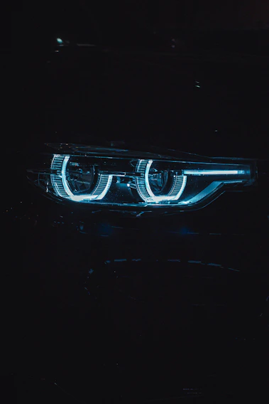 Close-up of a sleek vehicle headlight glowing brightly with Broled LED technology at dusk
