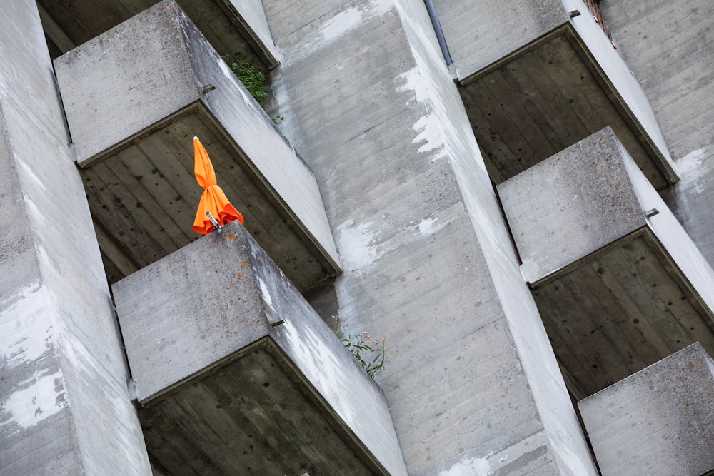 an orange umbrella sitting on the side of a building