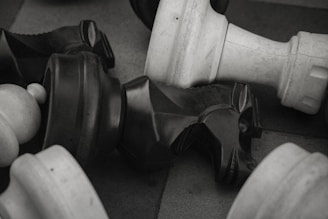 An overhead shot of several small, playful clay trinkets scattered around a chessboard.