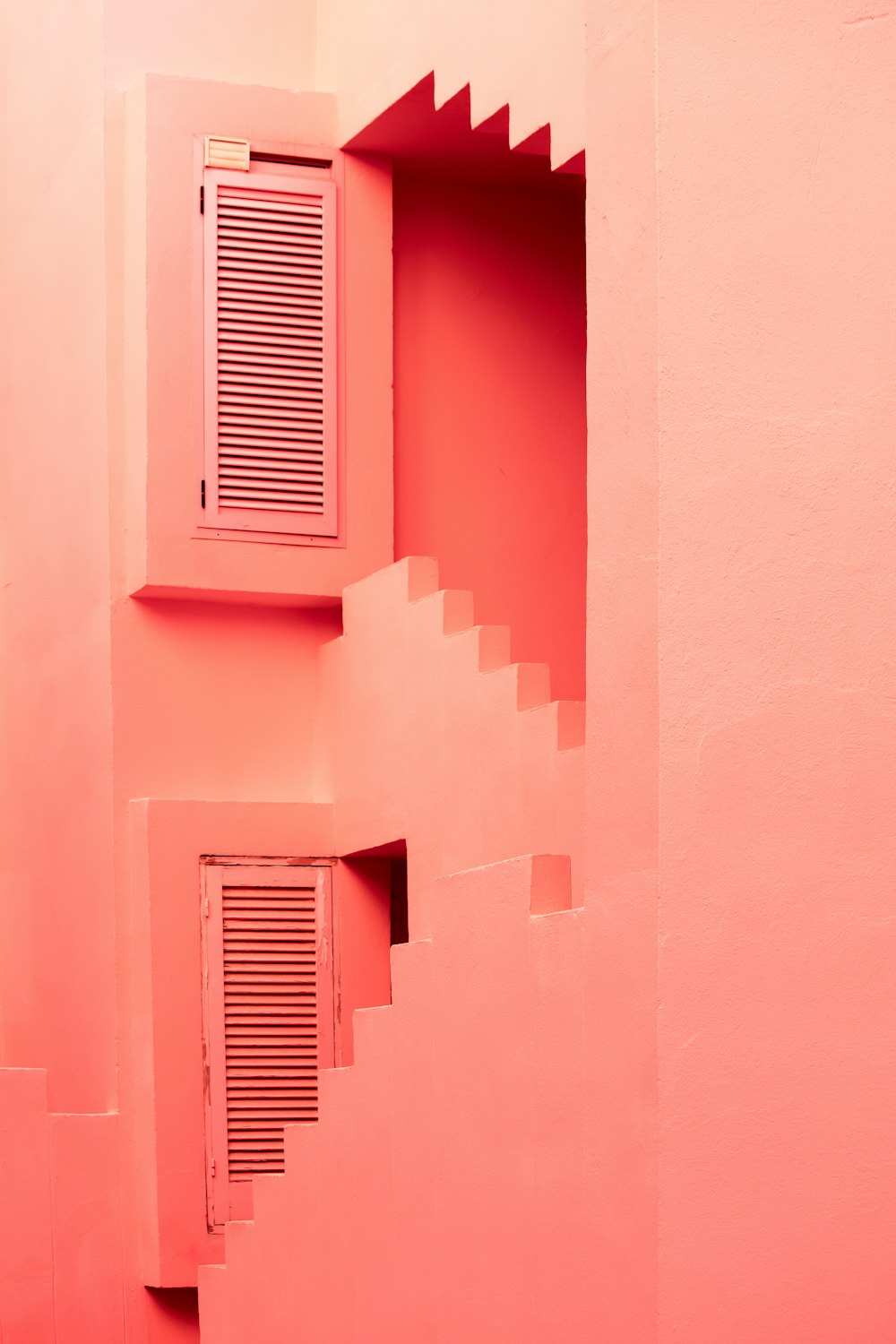 ein rosafarbenes Zimmer mit Fenster und Treppe