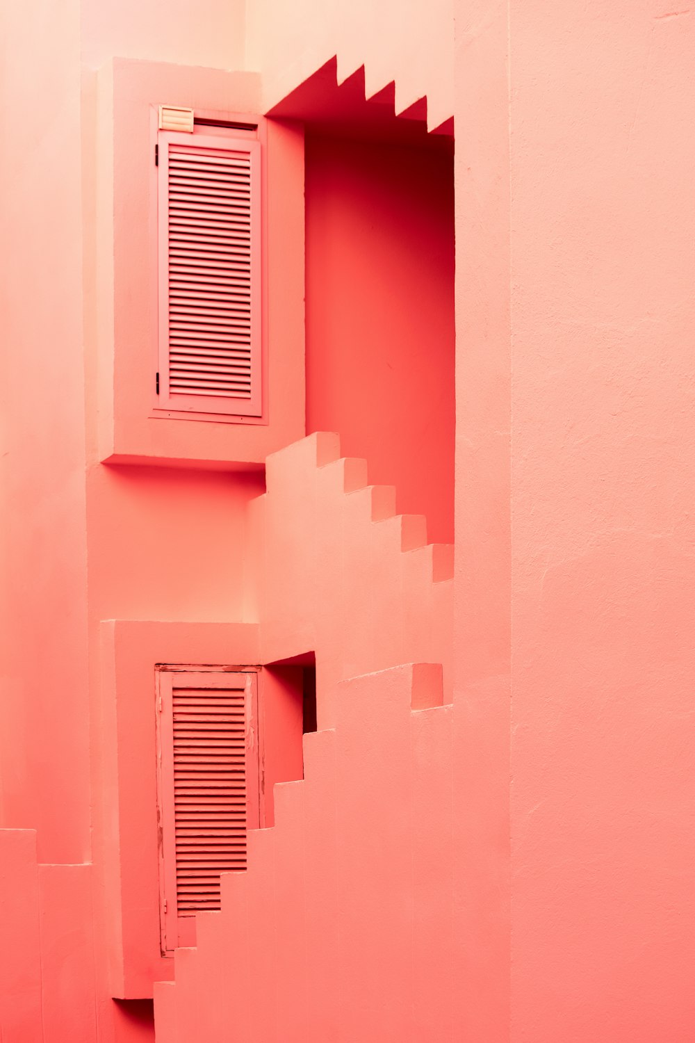 a pink room with a window and stairs