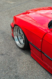 Close-up of a shiny car wheel and tire on a clean asphalt surface