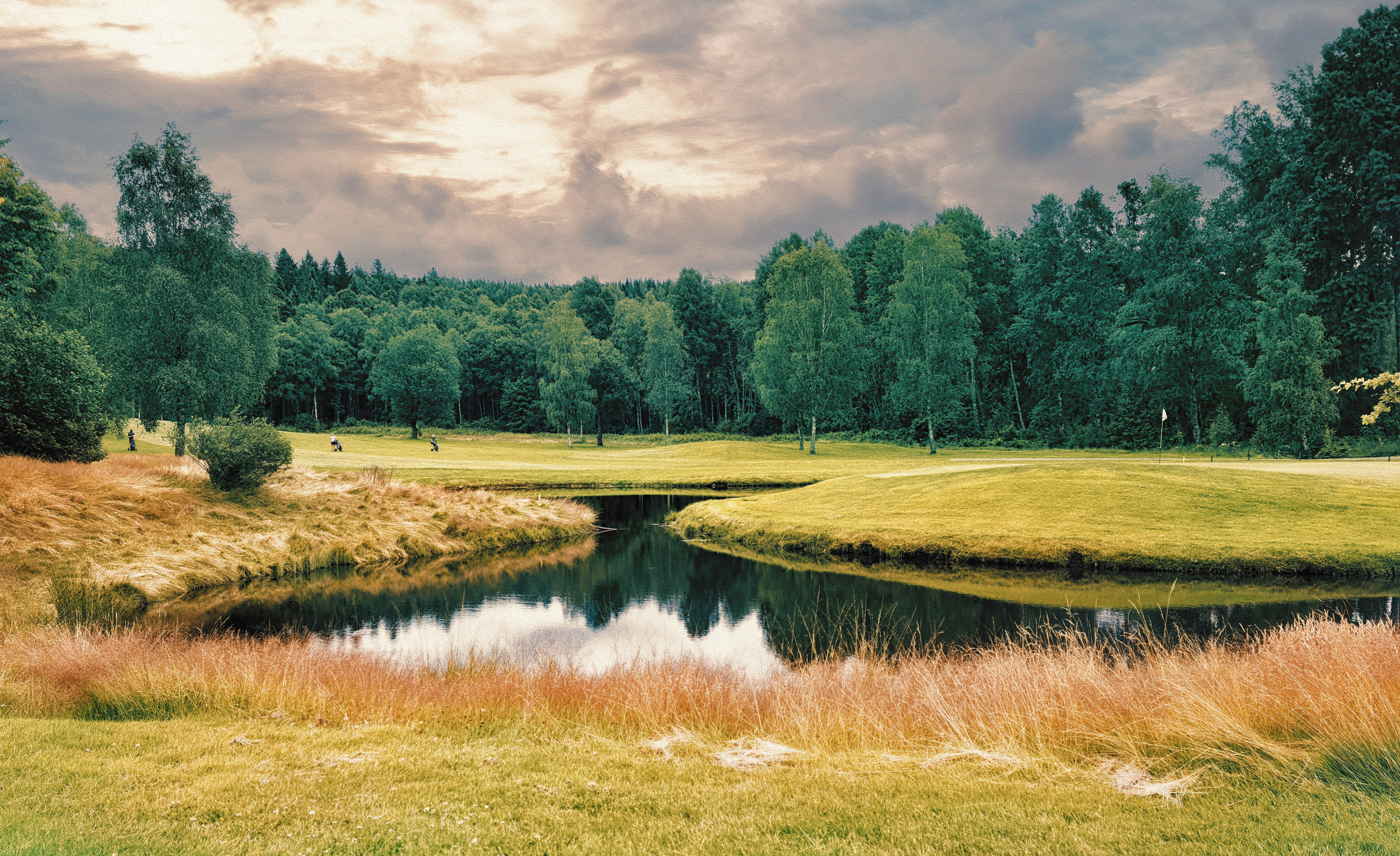 A golf course with a pond in the foreground photo Free Field Image on Unsplash