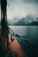A misty morning view of Prince of Wales Island’s dense forest meeting the calm sea, with a traditional Native Alaskan canoe resting on the shore.