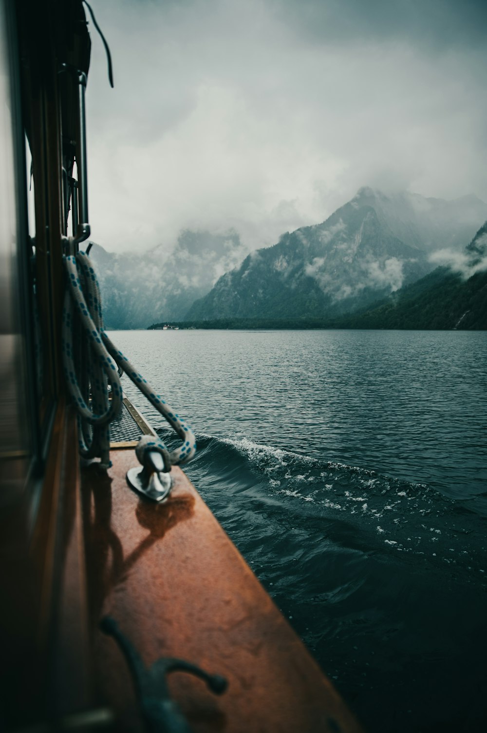 a boat traveling on a body of water with mountains in the background