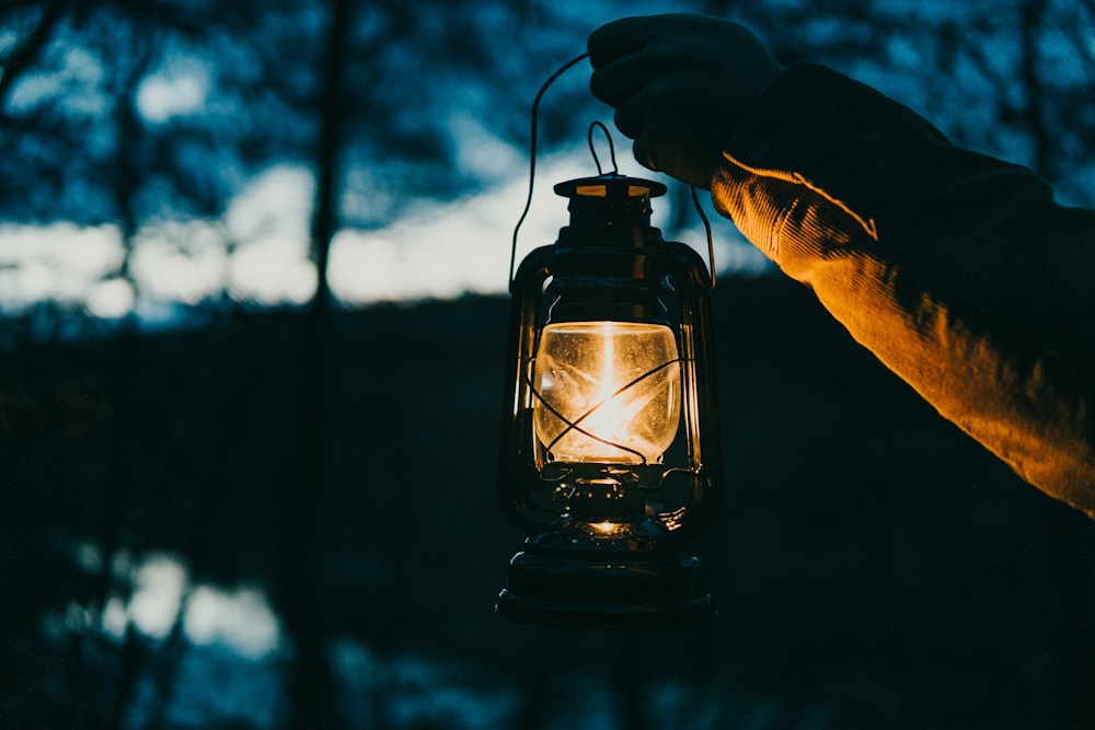 a person holding a lantern in their hand