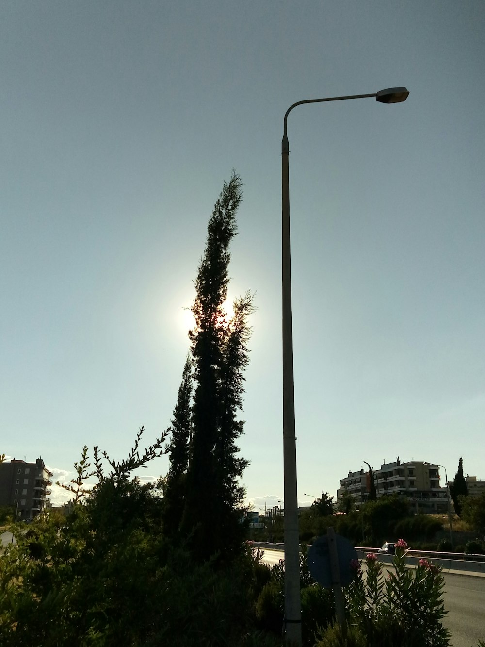 the sun is shining behind a street light