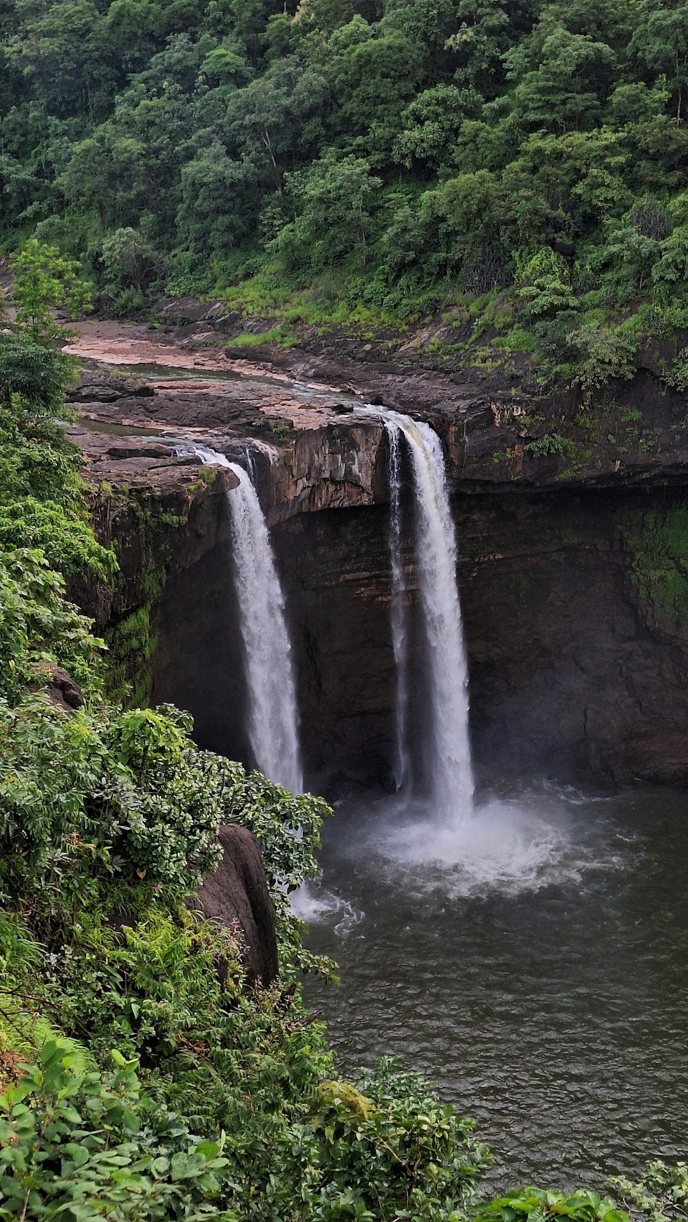 a large waterfall with water cascading down it's sides