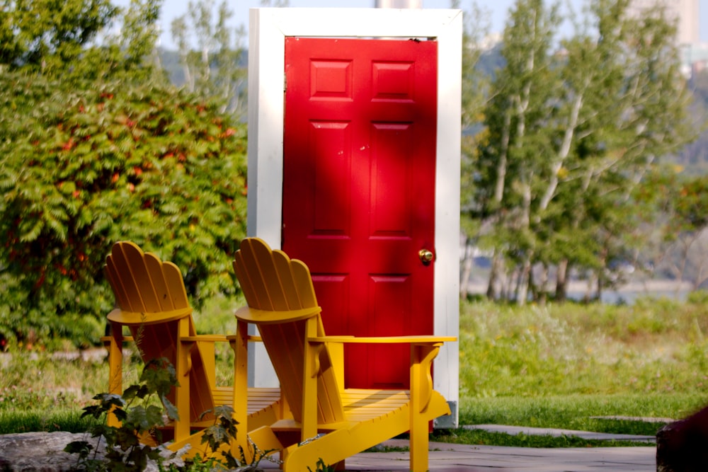 two yellow chairs sitting in front of a red door