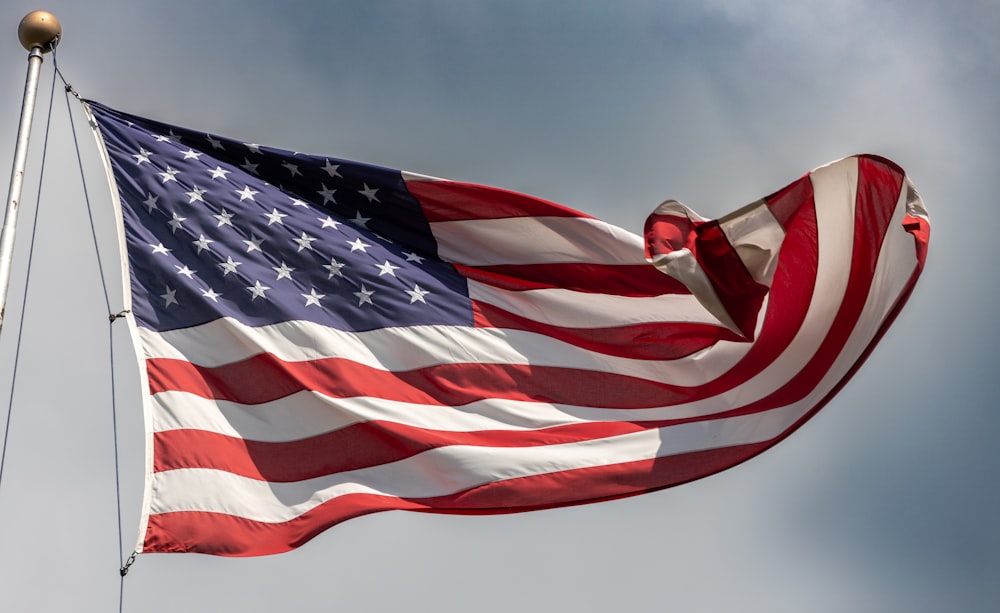 a large american flag flying in the wind