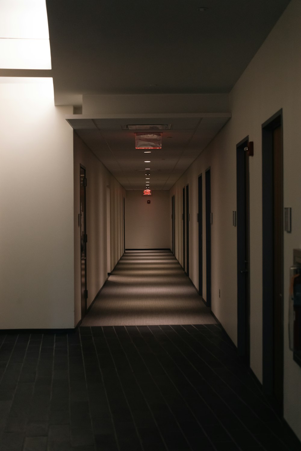 a long hallway with a red light on the ceiling