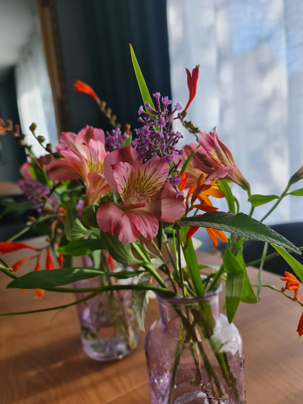 a wooden table topped with vases filled with flowers