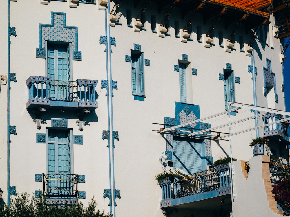 a white building with blue windows and balconies