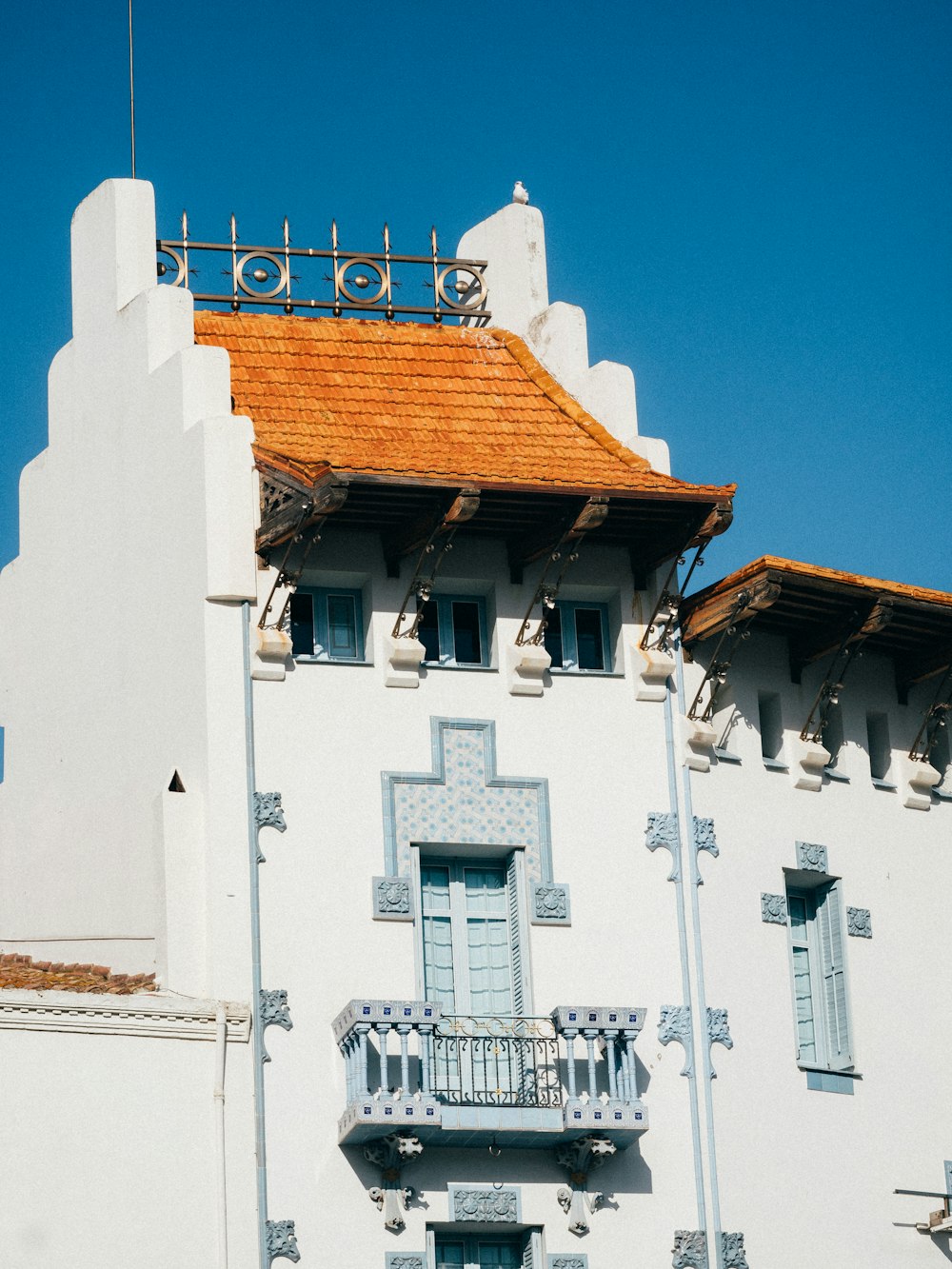 a tall white building with a red roof