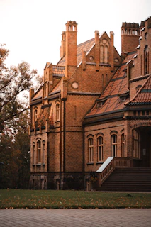 Historic brick station building surrounded by autumn trees with colorful leaves
