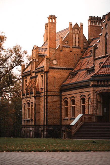 Historic brick station building surrounded by autumn trees with colorful leaves