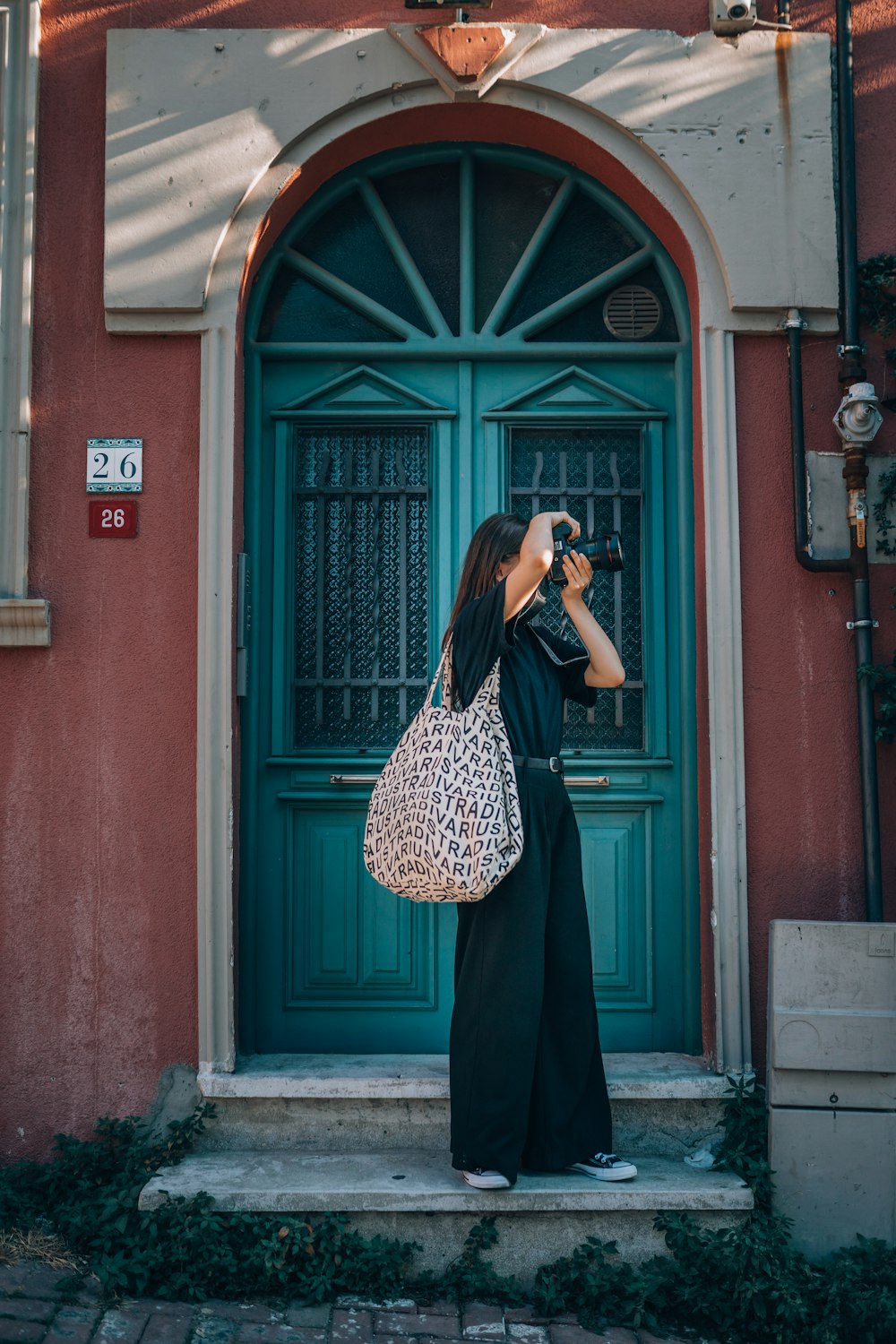 a woman taking a picture of a green door