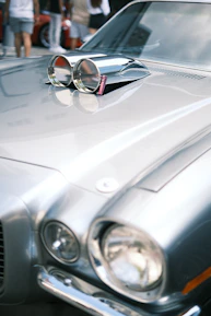 Close-up of a vintage car's polished chrome details reflecting the crowd.
