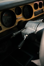 Close-up of vintage car dashboard with mechanic working in background.