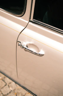 Close-up of a car door before and after hail damage repair showing smooth, flawless metal.