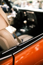 View of a car interior featuring leather seats and a focus on the door lock mechanism. The dashboard and gearshift are partially visible, with an emphasis on the sleek and polished design.