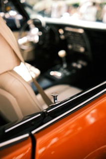 View of a car interior featuring leather seats and a focus on the door lock mechanism. The dashboard and gearshift are partially visible, with an emphasis on the sleek and polished design.