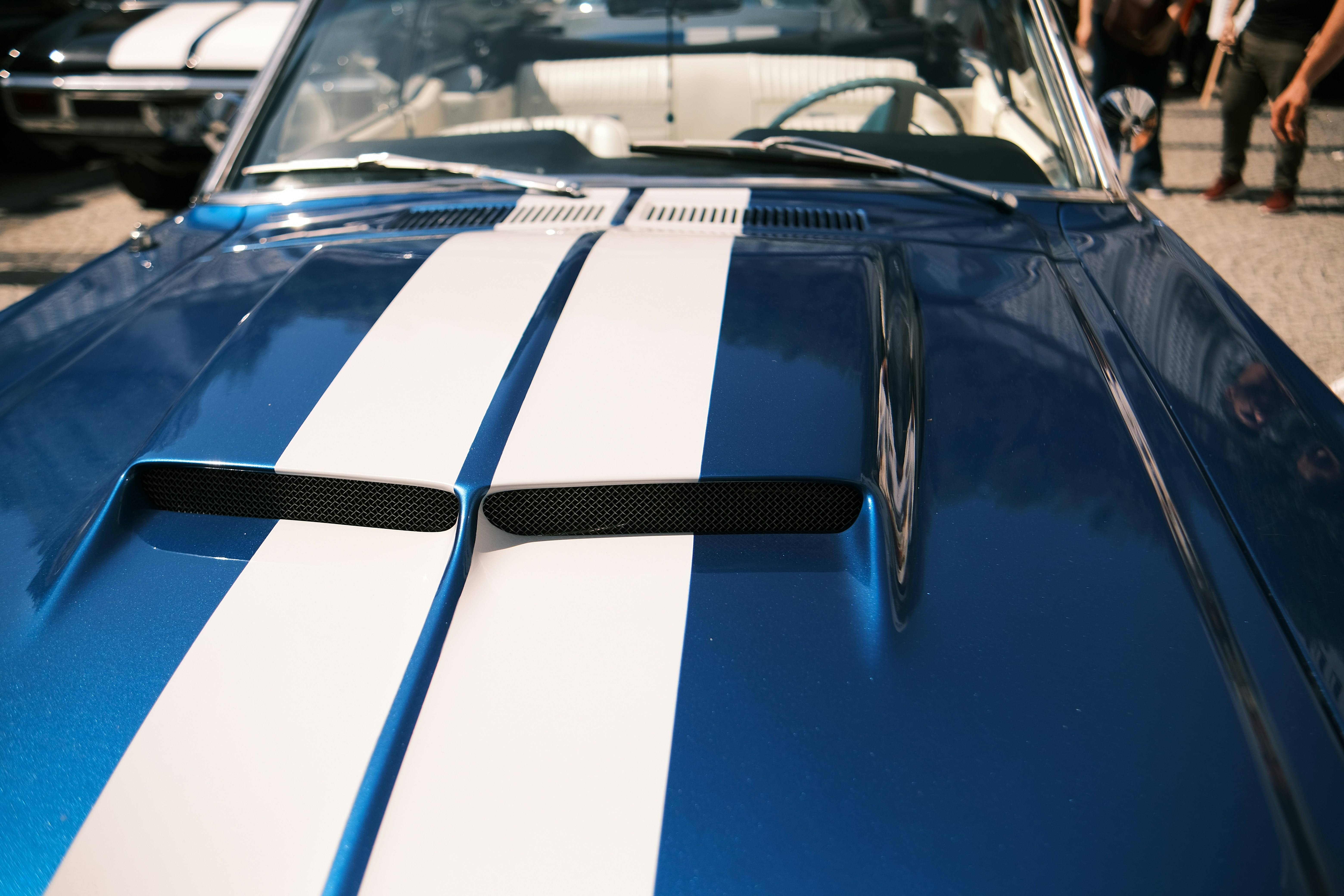a blue and white muscle car parked in a parking lot