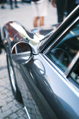 Close-up of a shiny, freshly washed car exterior reflecting Dublin cityscape.