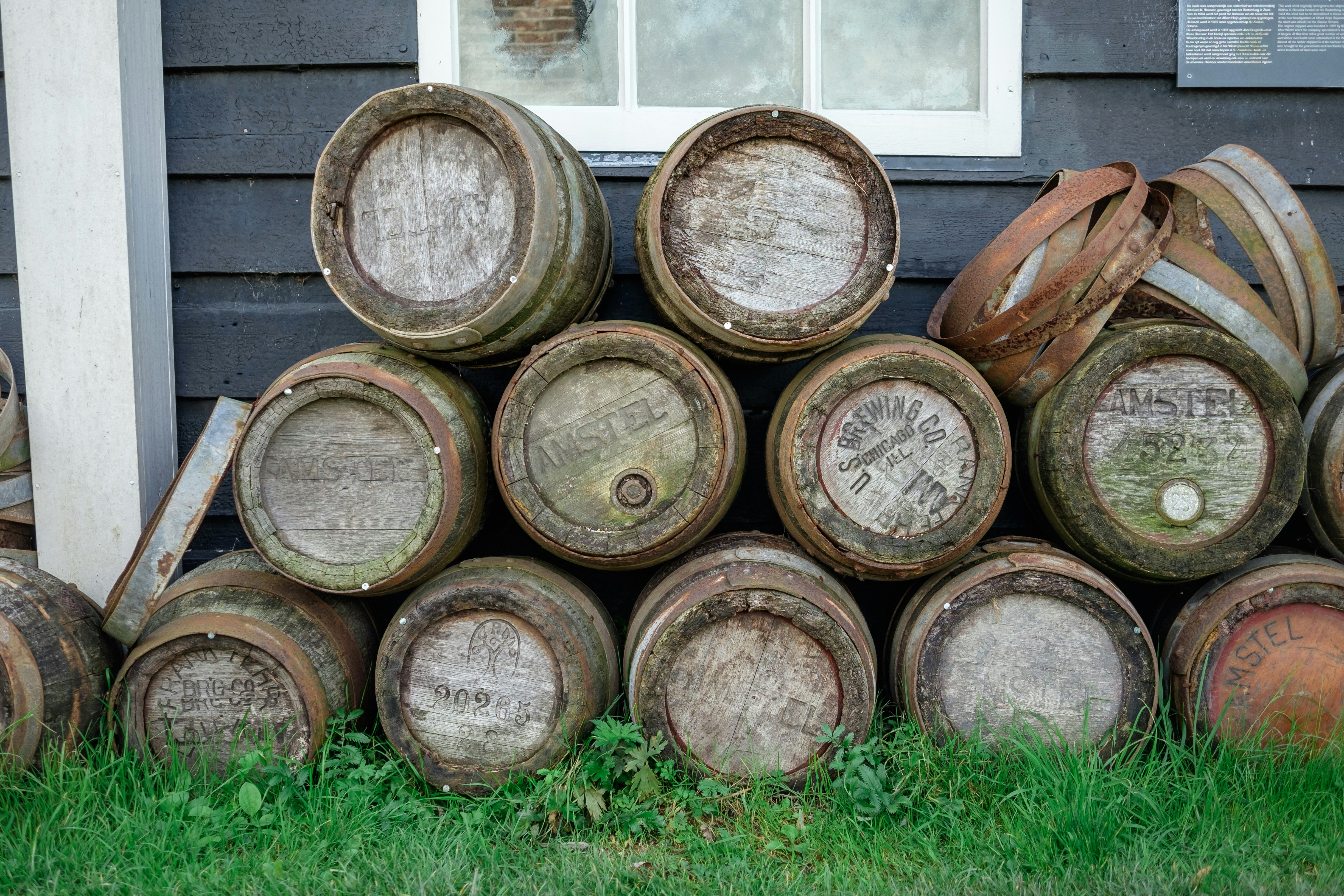 a pile of barrels sitting in front of a house