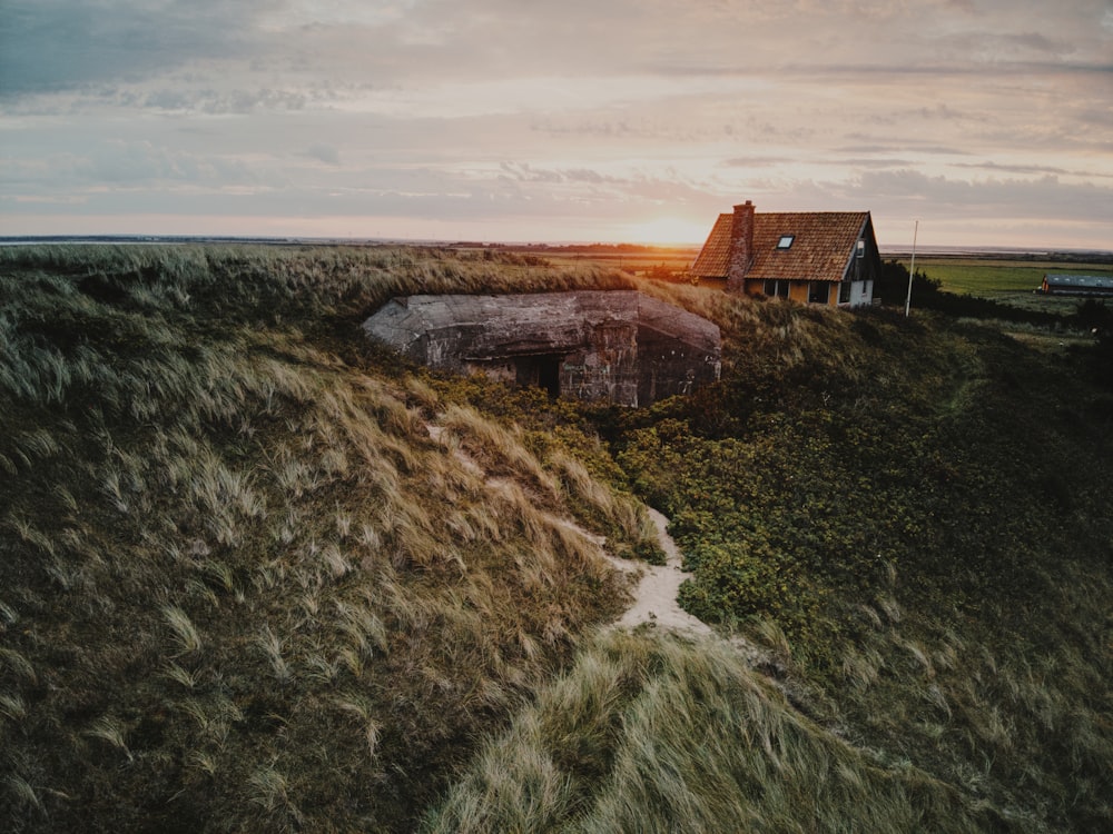 a house on top of a hill in the middle of a field